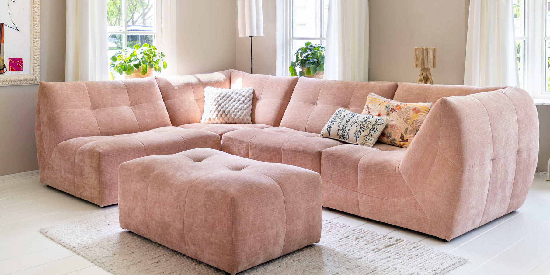 Roze designbank als kleuraccent in een lichte woonkamer Roze designbank als kleuraccent in een lichte woonkamer